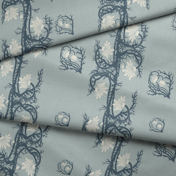 Marguerite in mist and slate: spined, entwined stems forming vertical channels around massed daisy heads, translated from a c. 1904 Dutch linen damask finger towel by Cornelis van der Sluys. fabric fold mockup