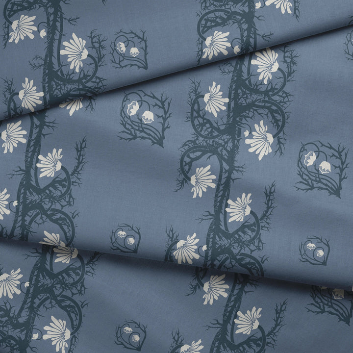 Marguerite in dusty blue and slate: spined, entwined stems forming vertical channels around massed daisy heads, translated from a c. 1904 Dutch linen damask finger towel by Cornelis van der Sluys. fabric fold mockup