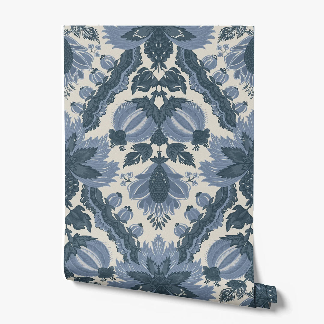 Flowering Pomegranate in linen and dusty blue: an ogee lattice of lace borders framing a blossom held between two swelling pomegranates, translated from an 18th-century French block-printed quilt. printed wallpaper roll